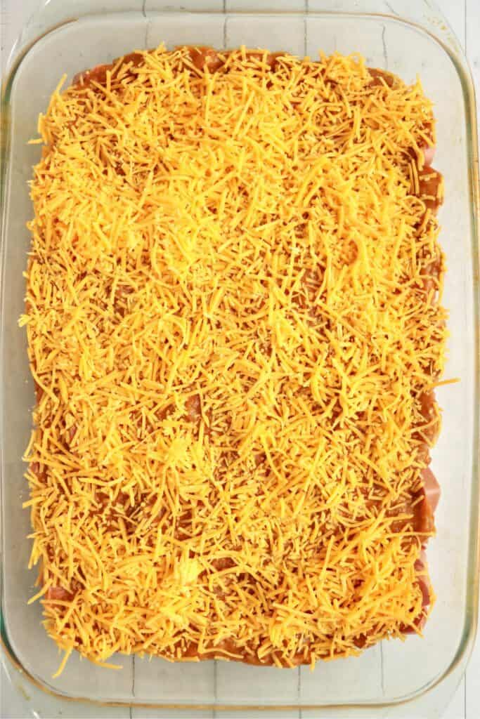 Overhead shot of cheese, chili, and hot dogs in baking dish