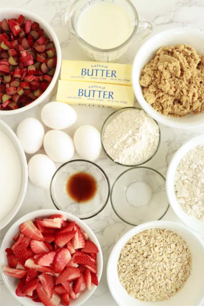 Overhead shot of individual rhubarb custard bars ingredients in bowls on table