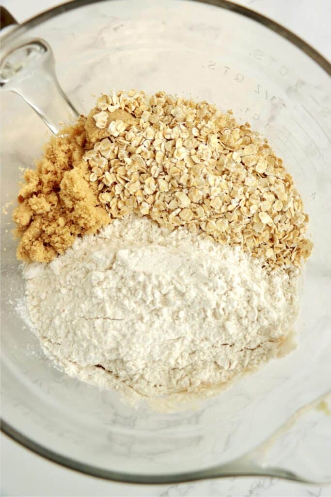 Overhead shot of butter, flour, brown sugar, and oatmeal in bowl