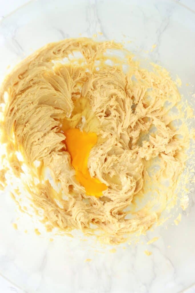 Closeup overhead shot of beaten egg in bowlful of beatedn peanut butter cream cheese mixture