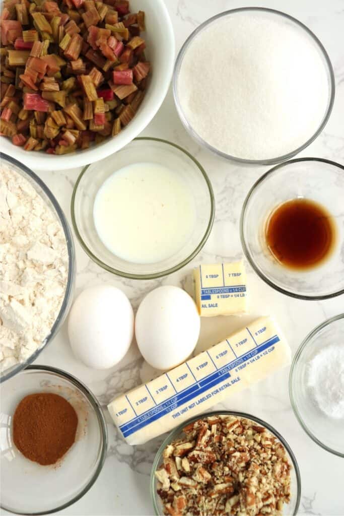 Overhead shot of individual rhubarb nut bread ingredients in bowls on table