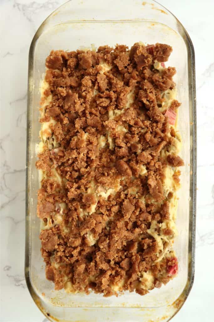 Overhead shot of rhubarb nut bread batter topped with streusel topping in bread pan