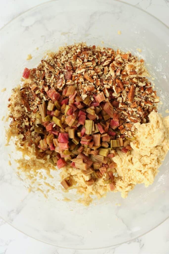 Overhead shot of bread batter with rhubarb and pecans on top