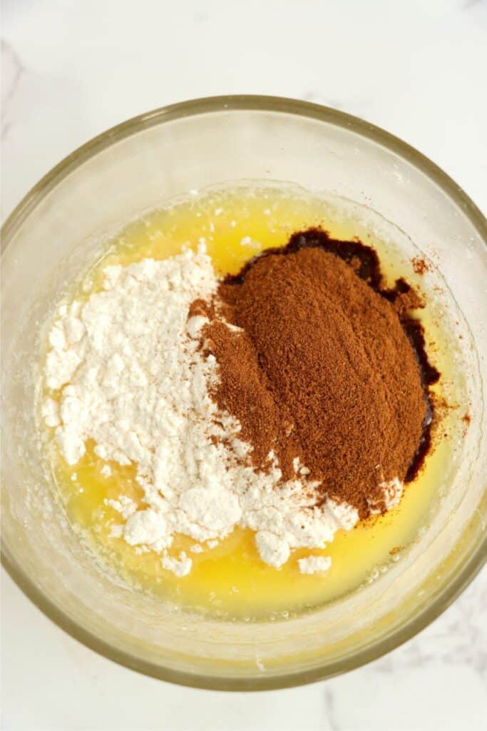 Closeup overhead shot of butter, sugar, flour, and cinnamon in mixing bowl.