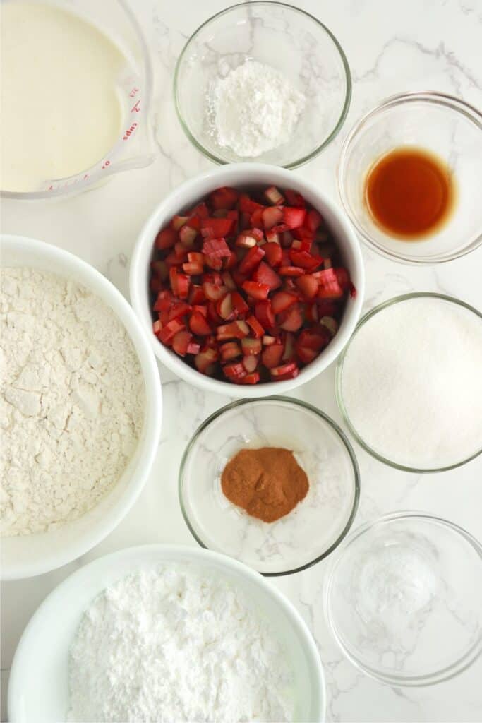 Overhead shot of individual ingredients for homemade rhubarb scones in bowls on table