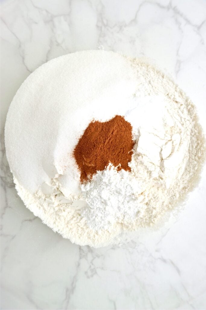 Overhead shot of flour, cinnamon, sugar, baking powder, and baking soda in bowl. 