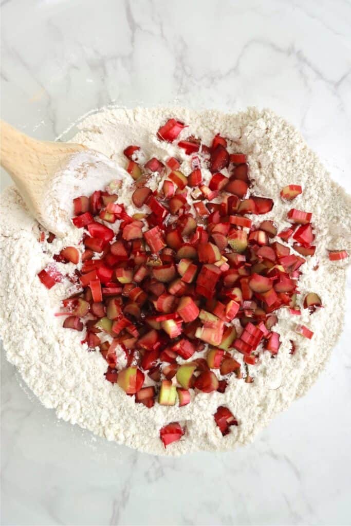 Overhead shot of dry scone ingredients with rhubarb on top. 