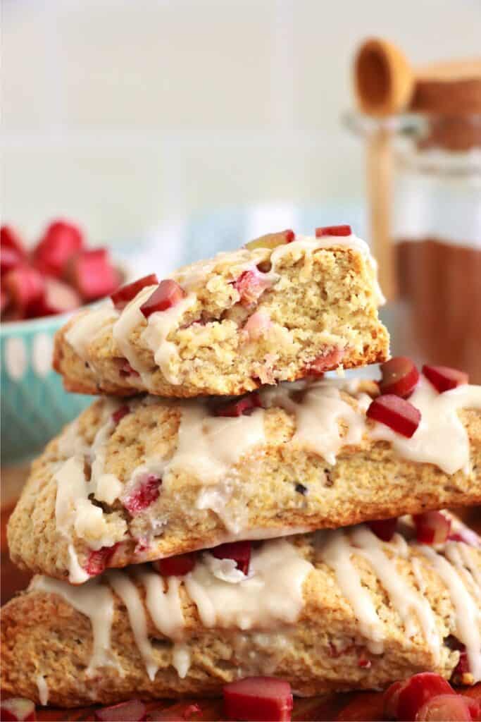 Closeup shot of three homemade rhubarb scones stacked atop one another with bite taken out of top scone