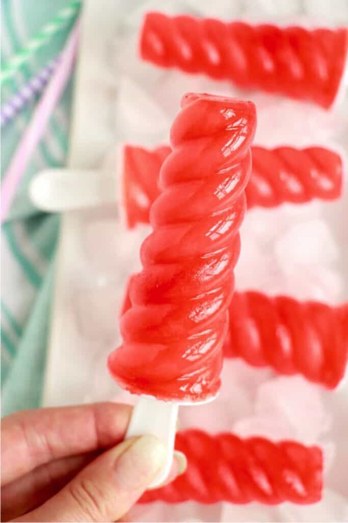 Closeup shot of hand holding a Kool Aid popsicle