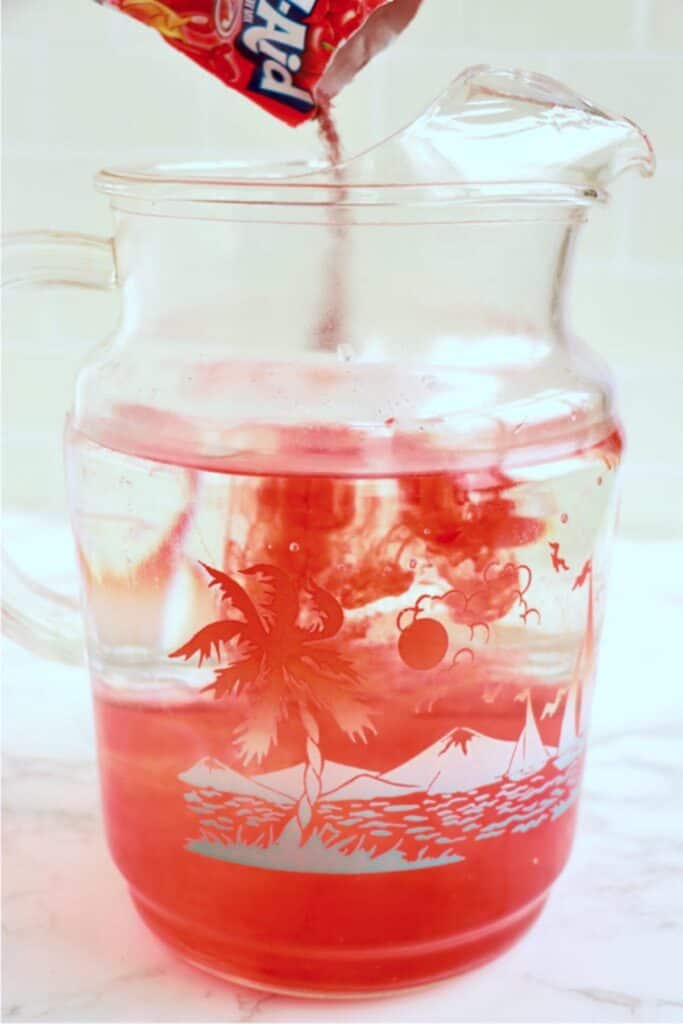 Packet of Kool Aid being poured into pitcher