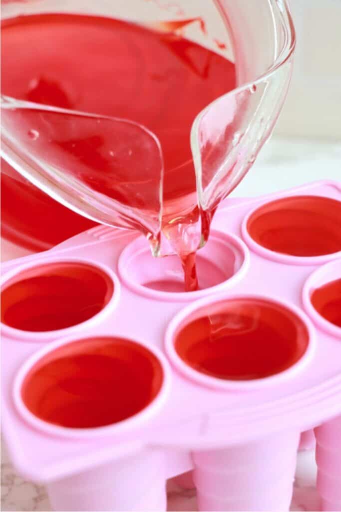 Closeup shot of Kool Aid being poured into popsicle molds