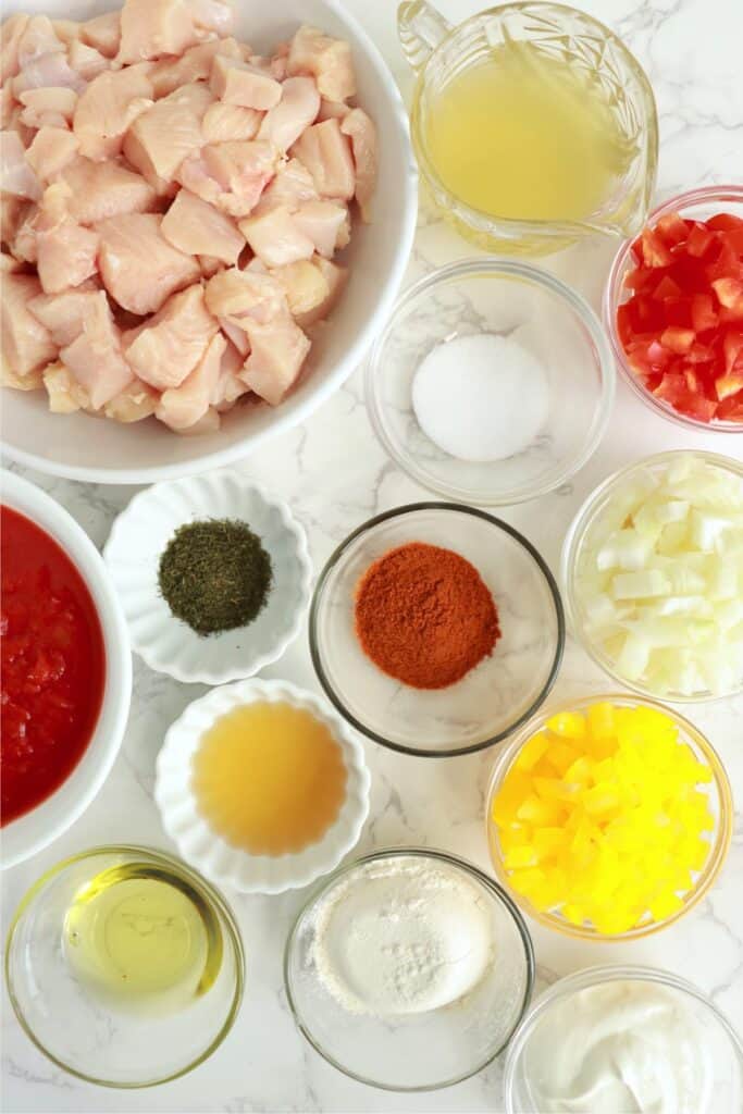 Overhead shot of individual slow cooker chicken paprikash ingredients in bowls on table