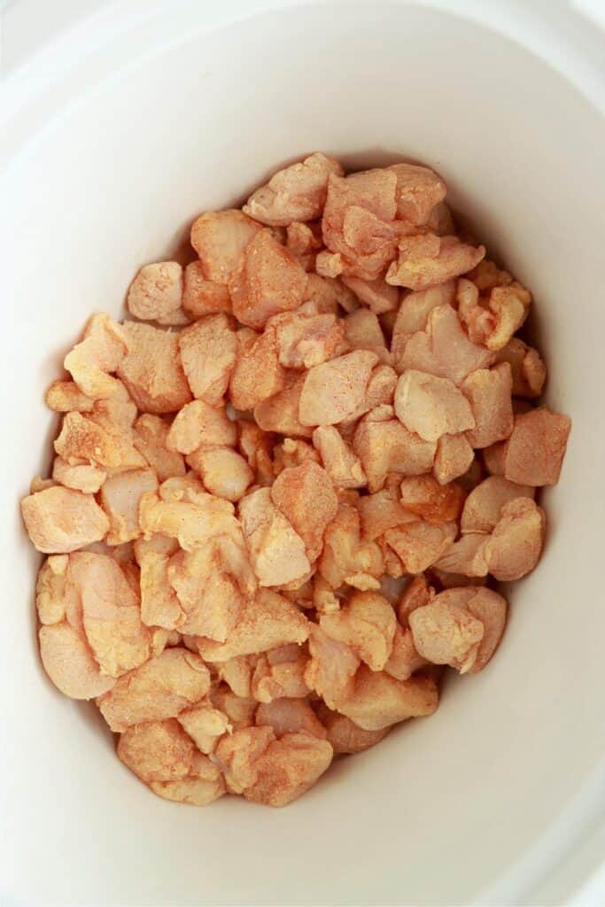 Overhead shot of cubed chicken in slow cooker