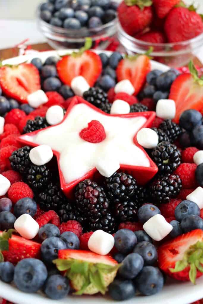 Cloesup shot of 4th of July fruit tray with berries and a star-shaped bowl of yogurt in the center. 