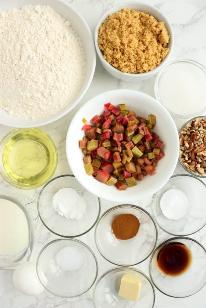 Overhead shot of ingredients for homemade rhubarb muffns in individual bowls on table