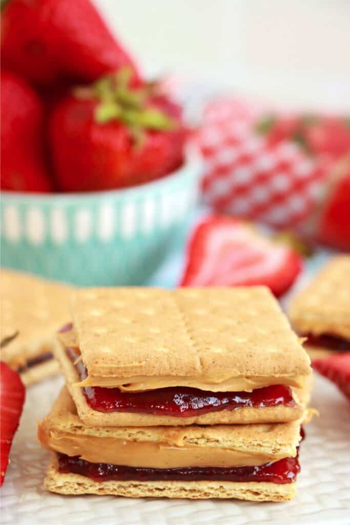 Two peanut butter and jelly graham cracker sandwiches stacked atop one another