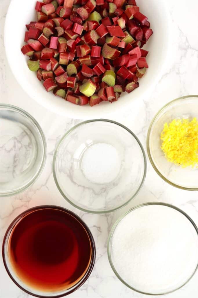 Overhead shot of pickled rhubarb ingredients in individual bowls on table