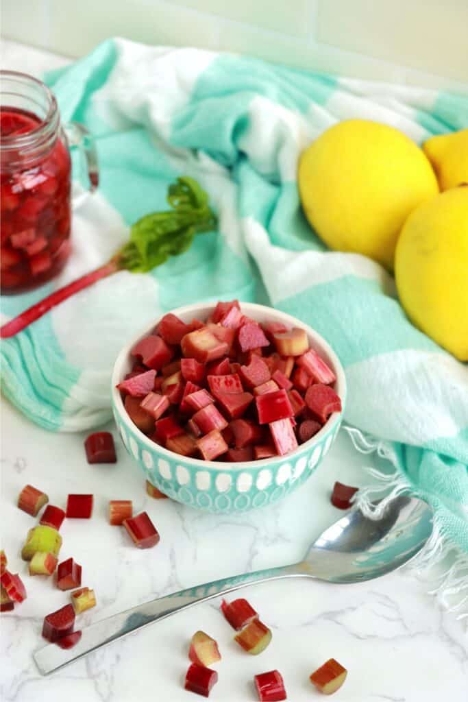 Bowlful of rhubarb with lemons and jar of pickled rhubarb in background