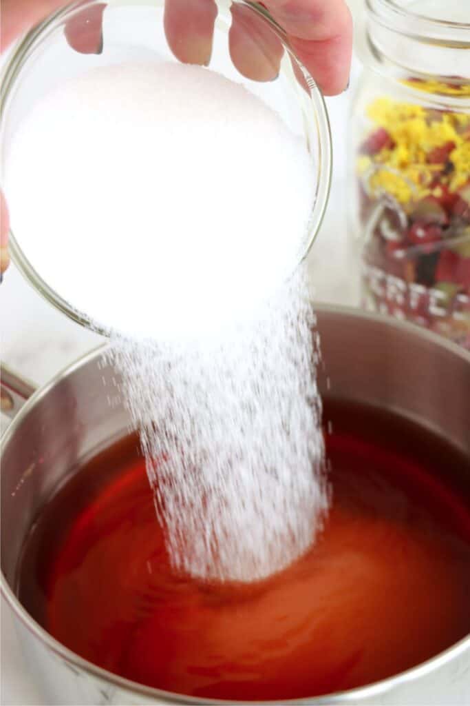 Sugar being poured into saucepan with water, vinegar, and salt. 