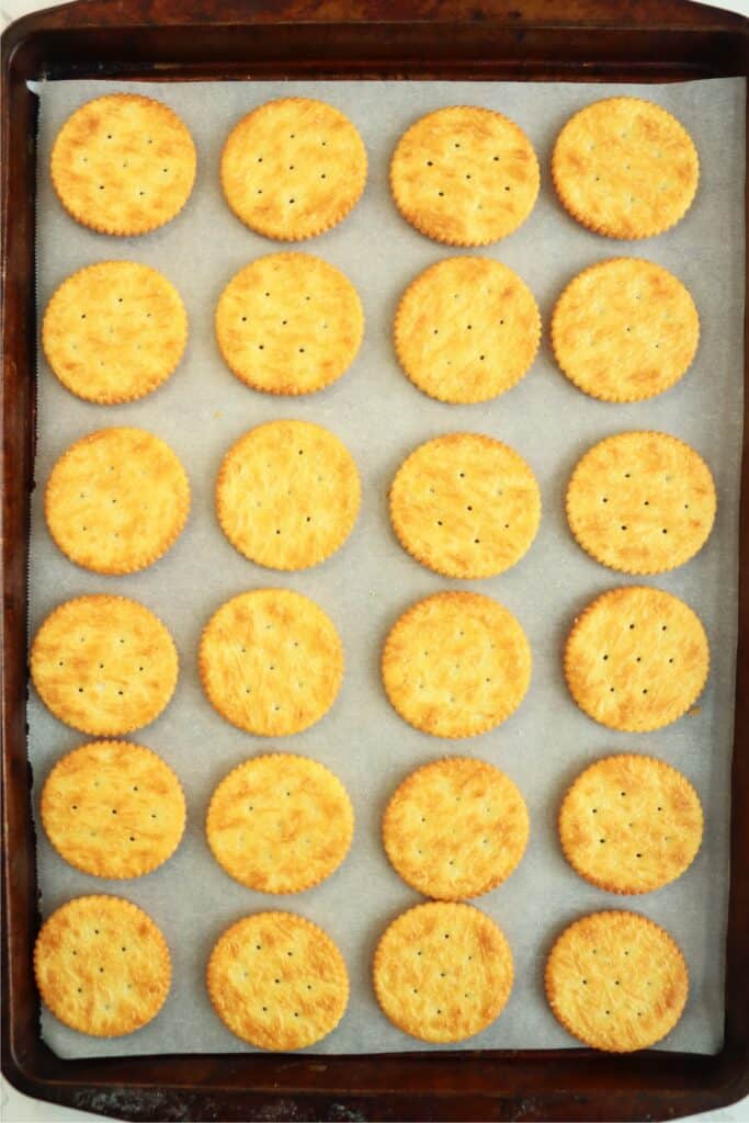 Overhead shot of Ritz crackers on baking sheet lined with parchment paper. 