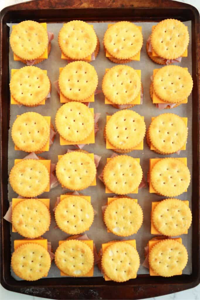 Overhead shot of Ritz cracker sandwiches on baking sheet.