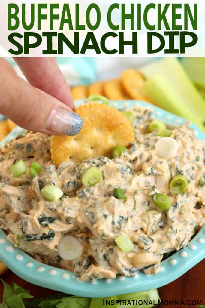 Closeup shot of hand dipping a Ritz cracker into buffalo chicken spinach dip