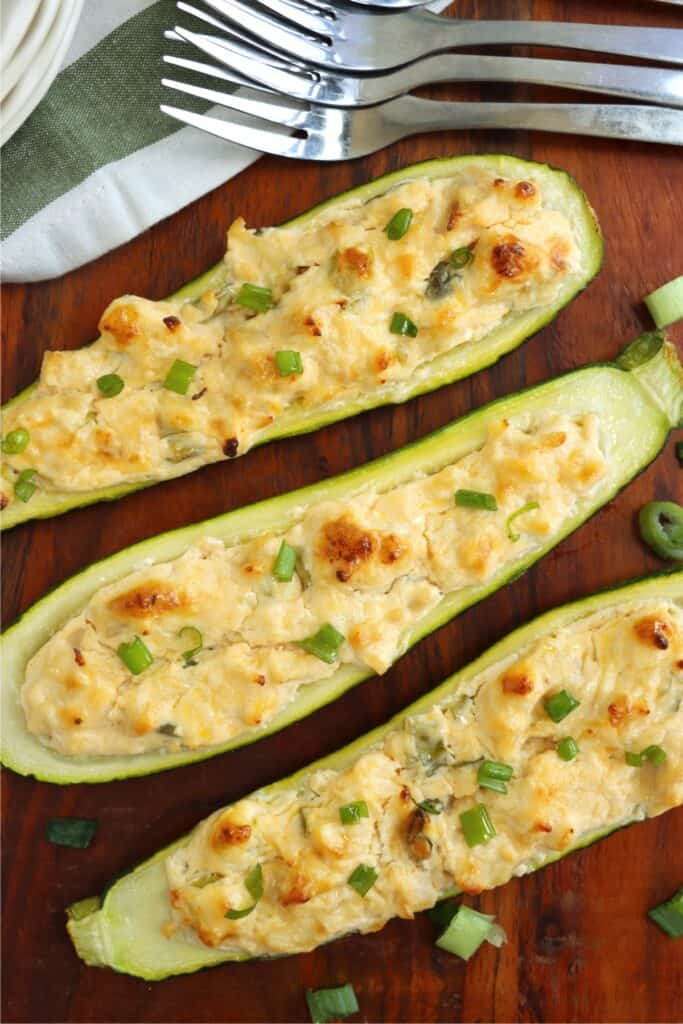 Overhead shot of three Buffalo chicken zucchini boats on table