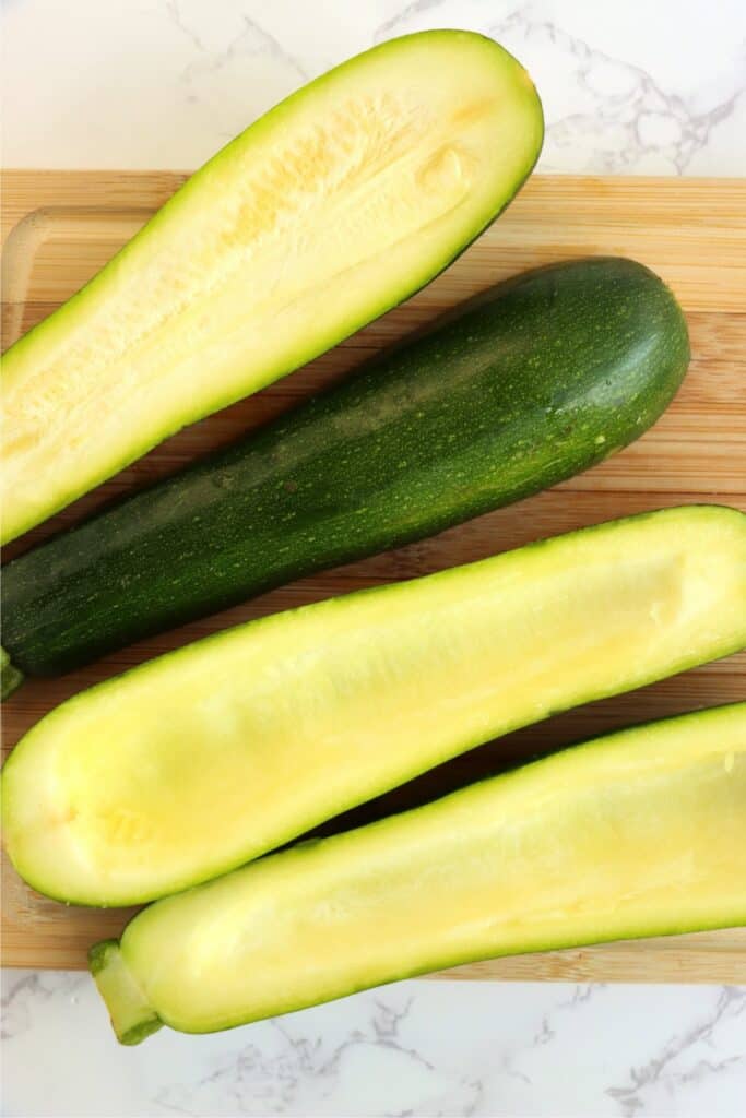 Overhead shot of zucchini slices in half with seeds removed.