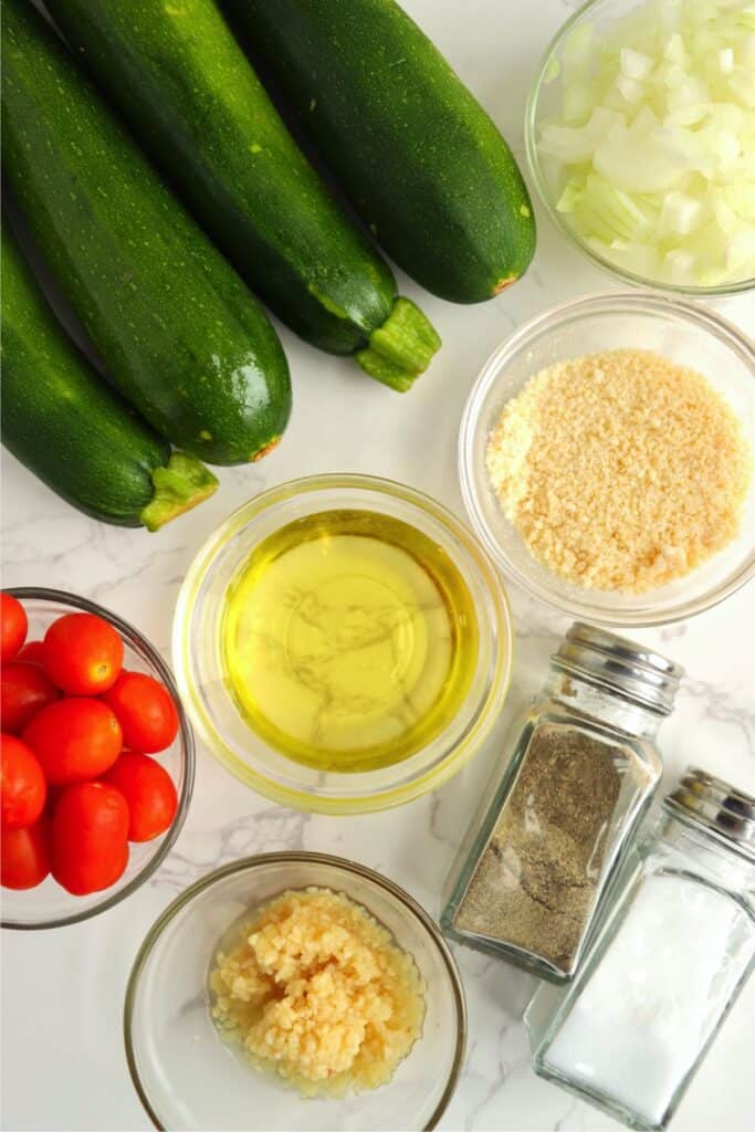 Overhead shot of ingredients for caramelized zucchini pasta in individual bowls