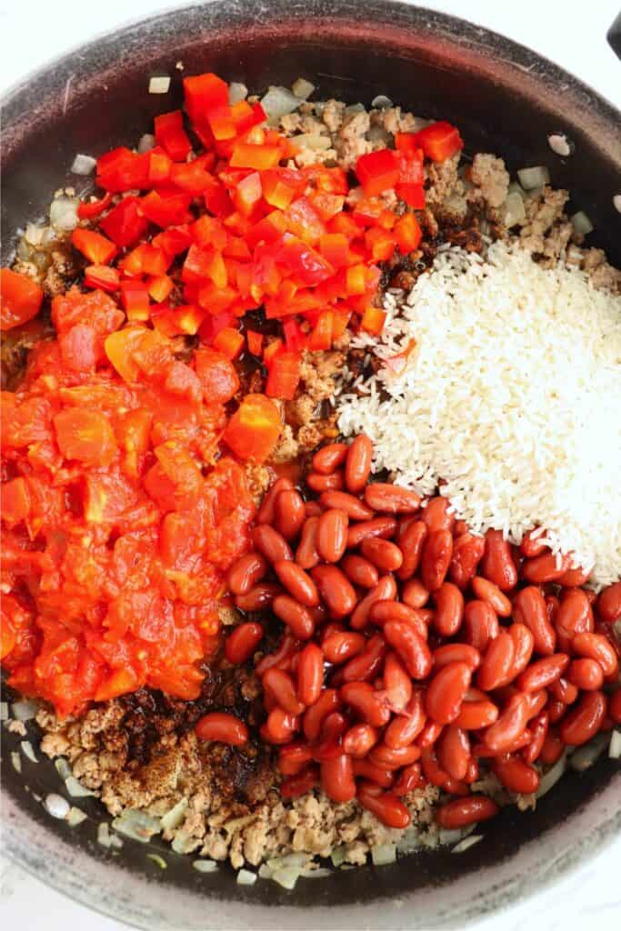Beans, tomatoes, and rice added to skillet with beef, onions, and spices.