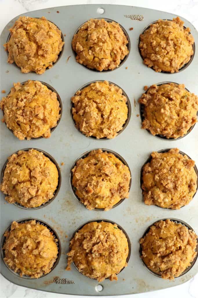 Overhead shot of baked pumpkin zucchini muffins in muffin tin.