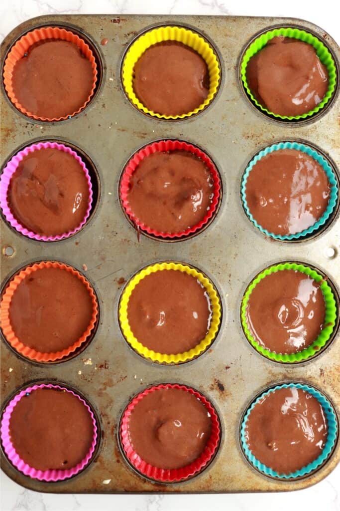 Overhead shot of unbaked cream cheese stuffed cupcakes in muffin tin