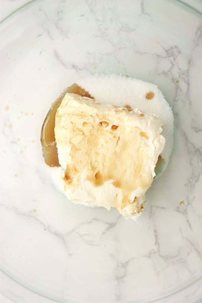 Overhead shot of crea cheese frosting ingredients in mixing bowl