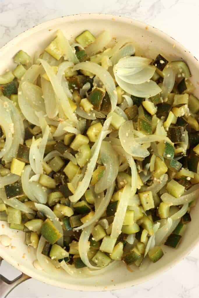 Overhead shot of skillet full of sauteed zucchini and onions. 