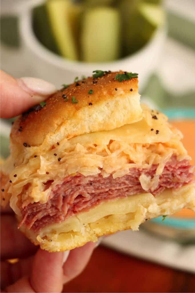  Closeup shot of hand holding a corned beef slider. 