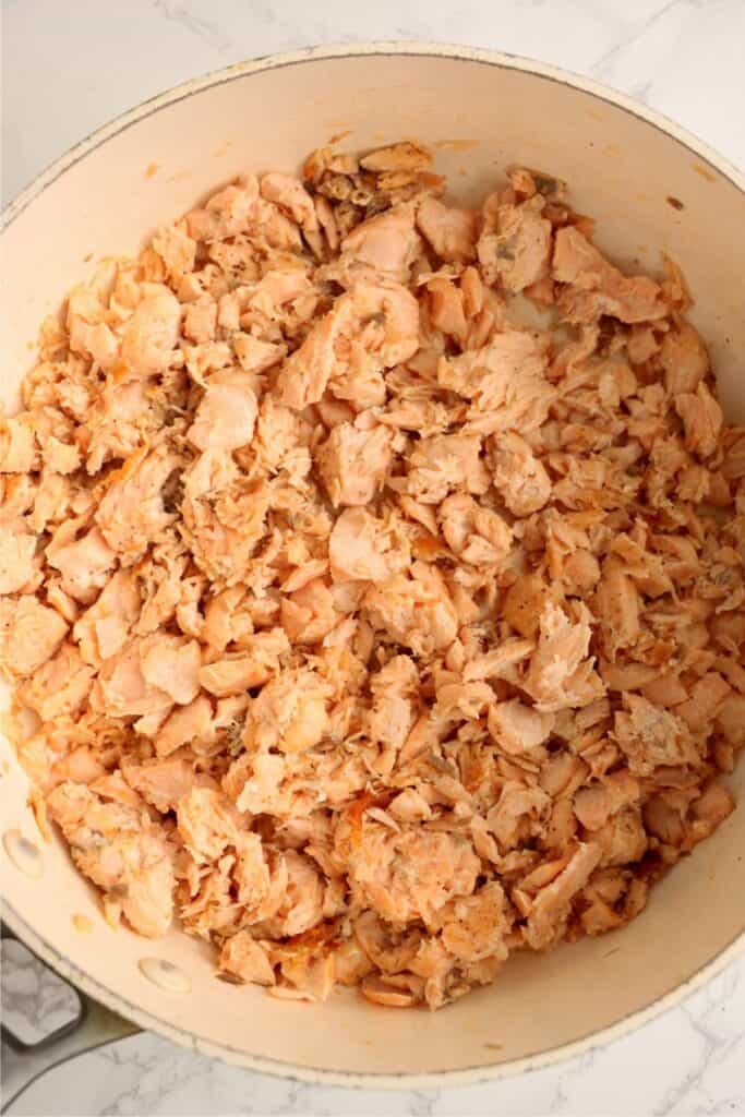 Overhead shot of flaked, cooked salmon in skillet. 
