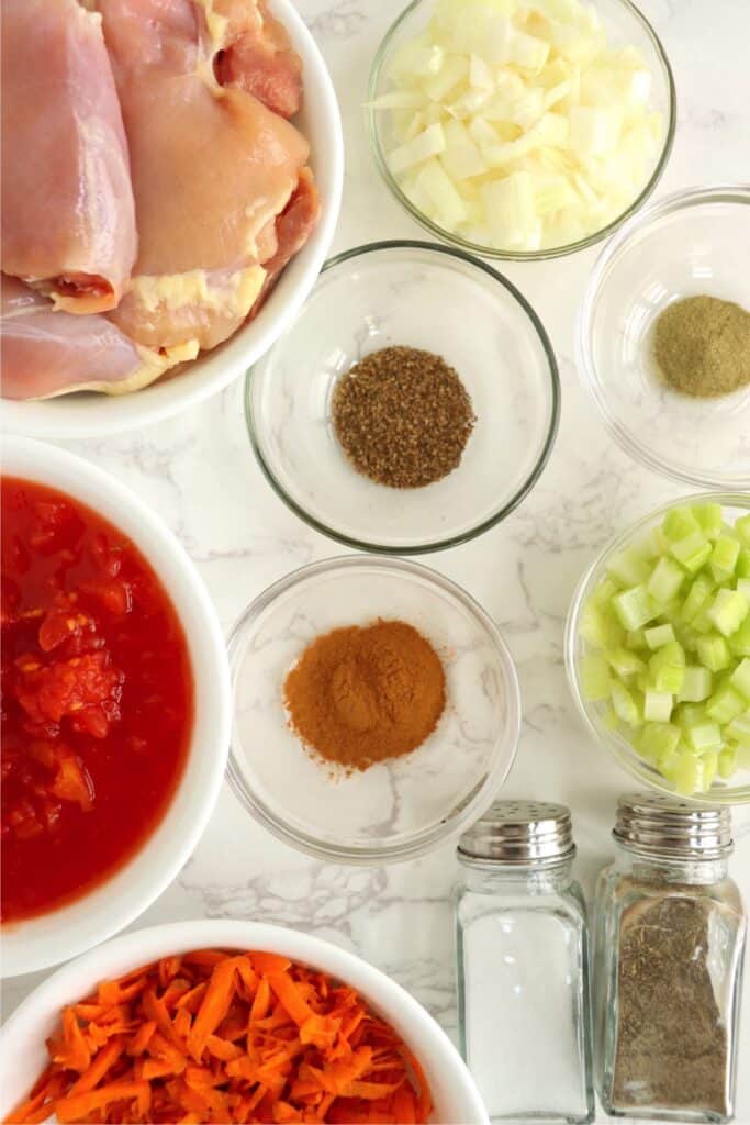 Overhead shot of individual slow cooker Moroccan chicken thighs ingredients in bowls on table