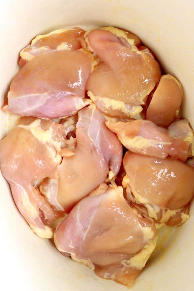 Overhead shot of raw chicken thighs in slow cooker