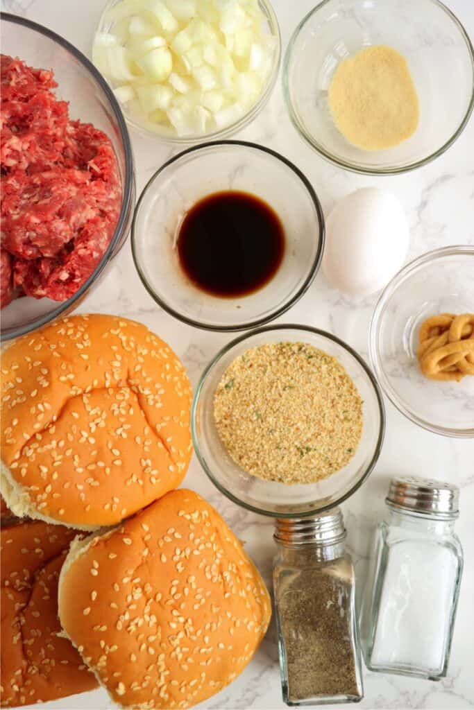 Overhead shot of classic American burger recipe ingredients in individual bowls on table