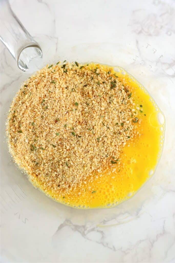 Overhead shot of eggs and breadcrumbs in bowl