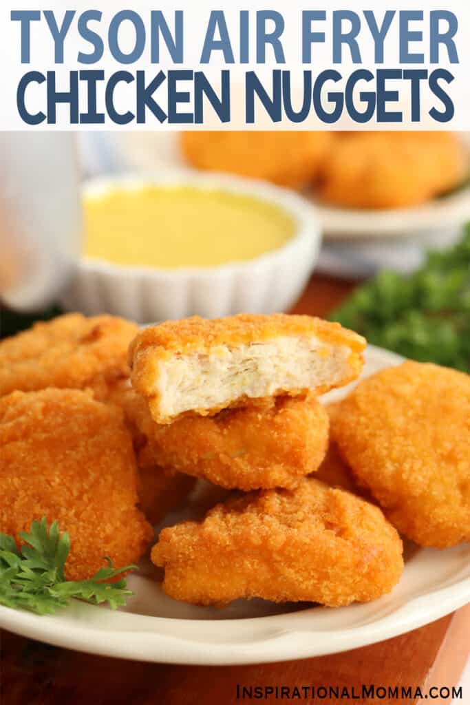 Closeup shot of pile of Tyson air fryer chicken nuggets on plate with bite taken out of top nugget. 