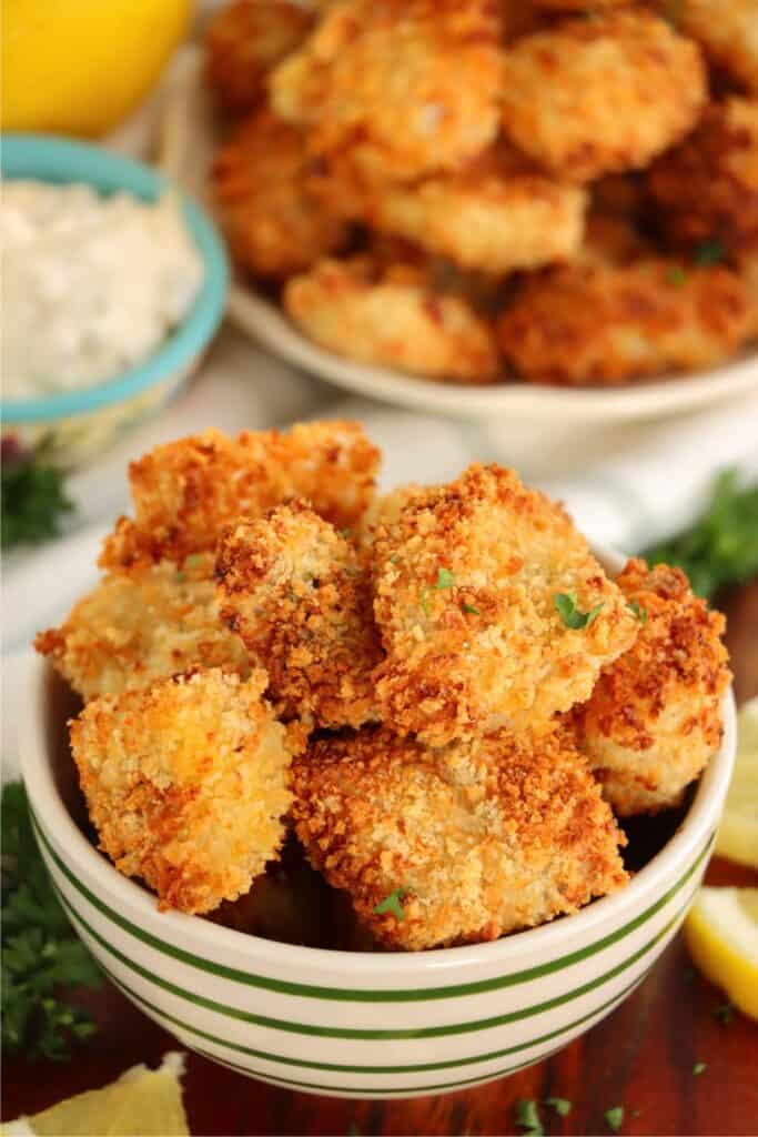 Bowlful of air fryer catfish nuggets with more nuggets in background. 