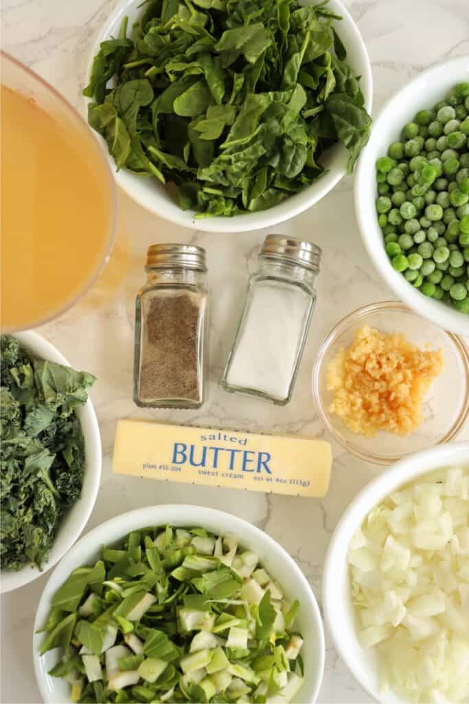 Overhead shot of individual kale and spinach soup ingredients in bowls on table. 