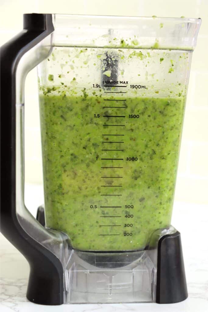 Closeup shot of blender full of blended vegetables. 