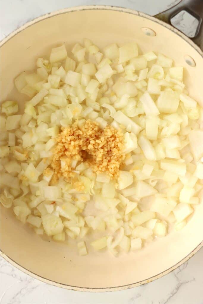 Overhead shot of onions and garlic in skillet. 