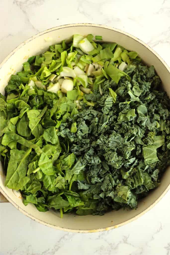 Overhead shot of skillet full ofkale, spinache, and bok choy. 