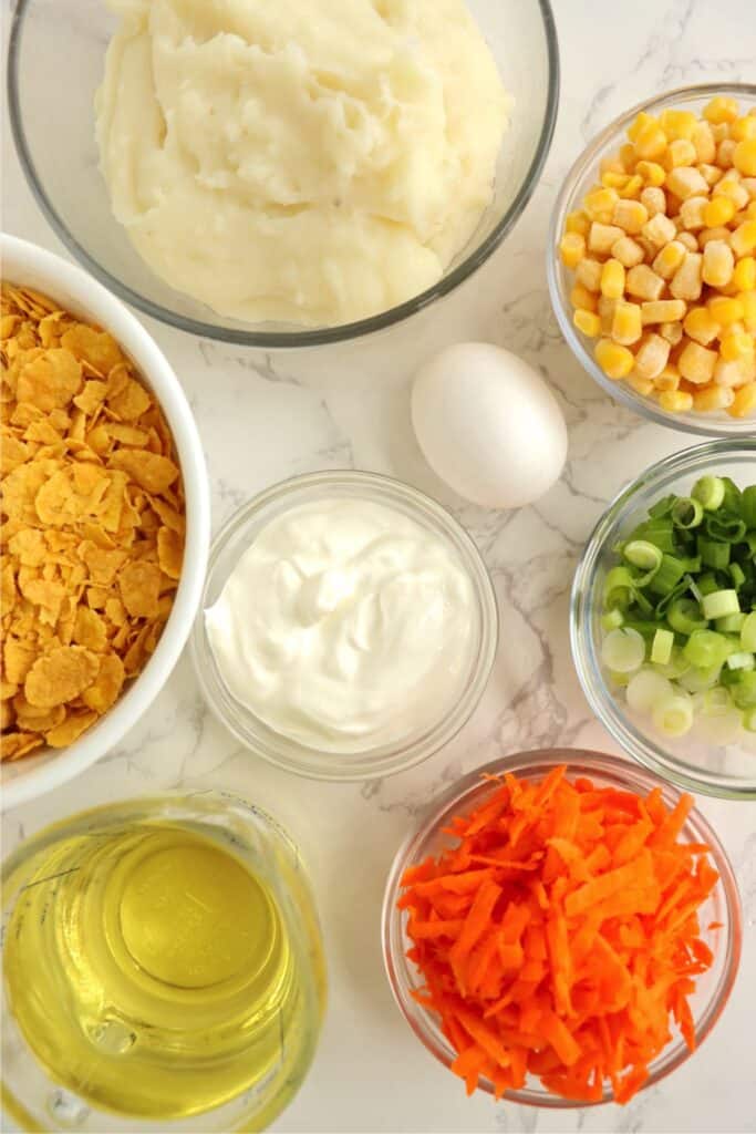 Overhead shot of individual mashed potato and vegetable patty ingredients in bowls. 