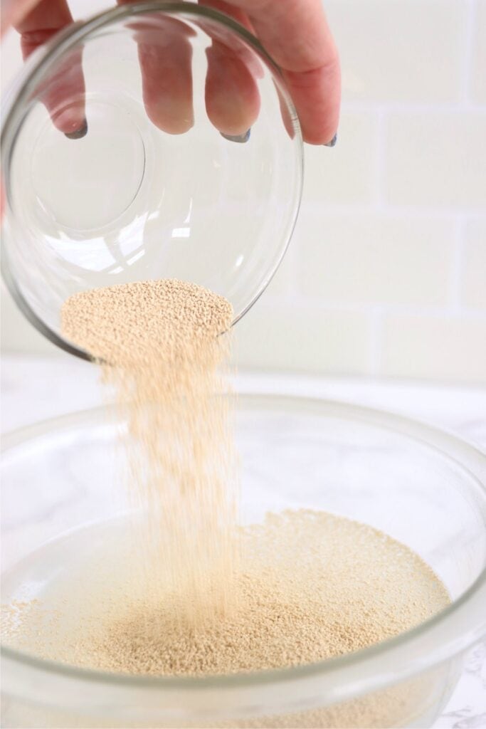 Closeup shto of yeast being poured into water.