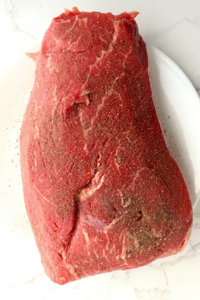 Overhead shot of seasoned beef roast on plate.