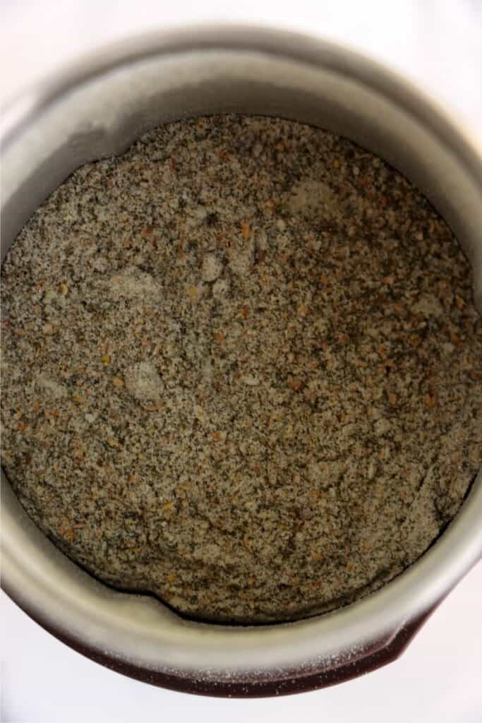 Closeup overhead shot of dill pickle seasoning in spice grinder. 
